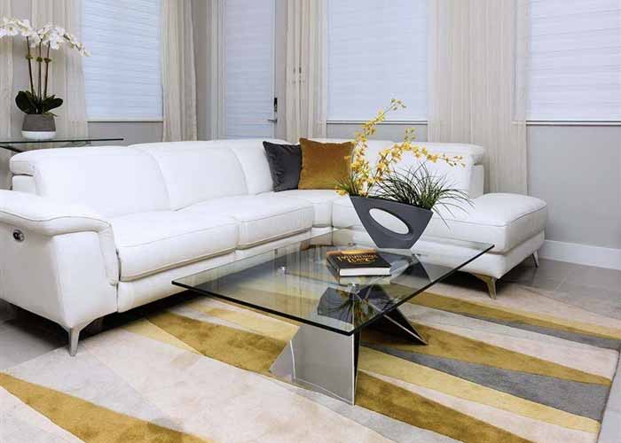 Sleek Spezia coffee table with a geometric glass top and a unique, angular metallic base, adding a touch of sophistication to the living area.